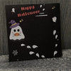Schwarze Karte mit rosa Text „Happy Halloween“ und weißen Geist- und Sterndekorationen.