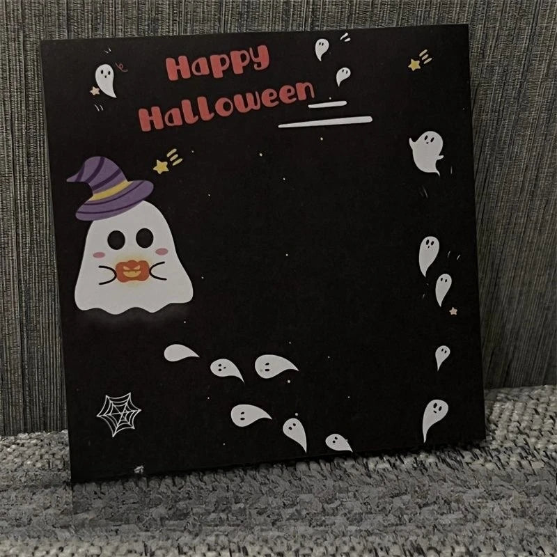 Schwarze Karte mit rosa Text „Happy Halloween“ und weißen Geist- und Sterndekorationen.