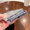 A hand holds a clear magnetic transparent phone case with multiple ports and buttons.