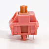 A pink rosewood linear mechanical keyboard switch with a plastic housing and metal pins.