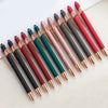 A collection of 12 retractable stylus and ballpoint pens in various shades of pink, red, and green are arranged on a white su