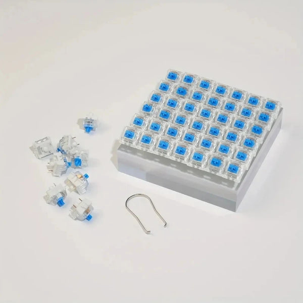 A white plastic tray filled with blue hot-swappable mechanical keyboard switches and a keycap puller tool.