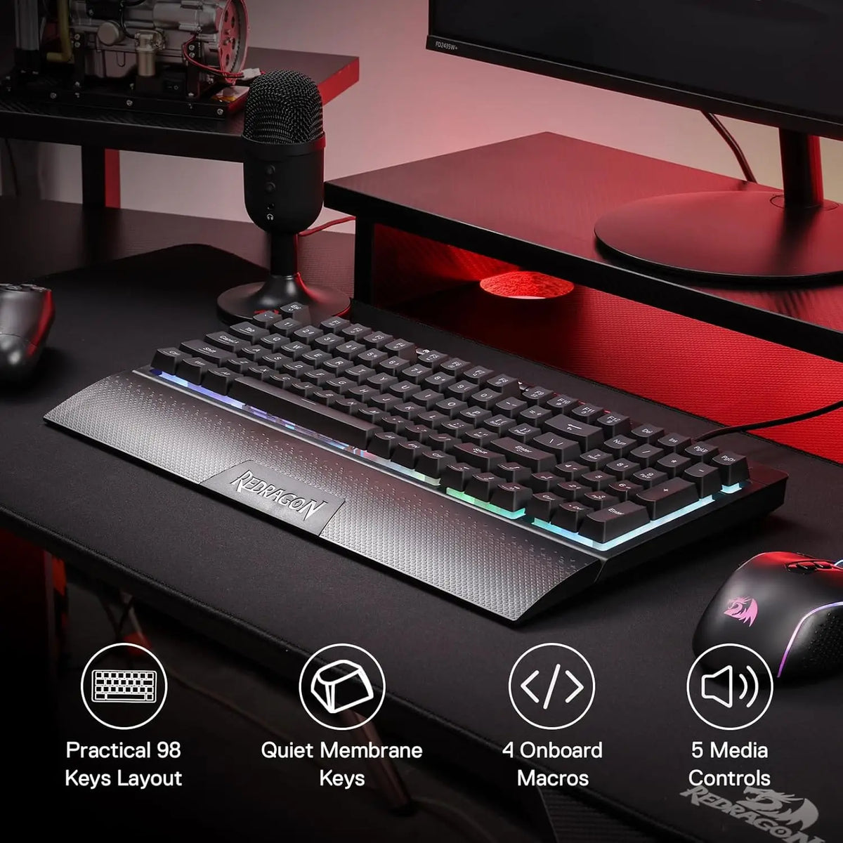 A close-up view of a black Redragon K515 Shiva wired RGB membrane gaming keyboard on a dark desk.