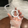 A hand holds a clear magnetic transparent phone case with a circular cutout and a small rectangular cutout.