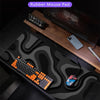 A black desk mat featuring an abstract, wavy pattern, with a mechanical keyboard and gaming mouse visible on the surface.