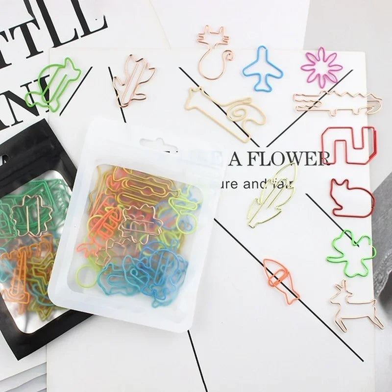 A collection of colorful decorative bookmarks and paper clips in various shapes and colors arranged on a white background.