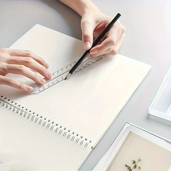 A hand uses a black pen to mark a clear acrylic folding ruler on a white notebook.