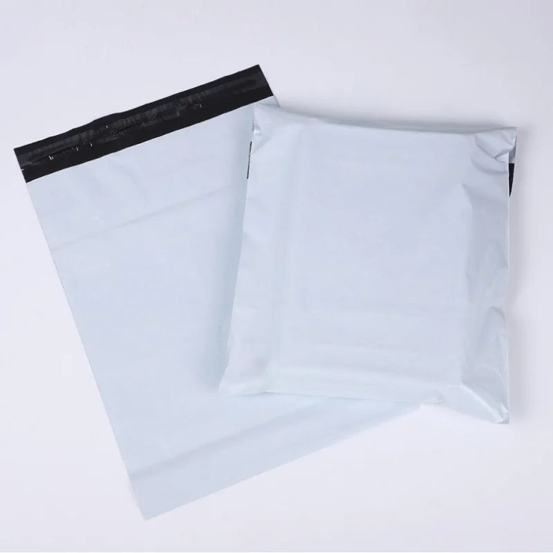 A stack of ten white self-sealing waterproof shipping bags with black seals.