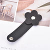 Black leather flower cable organizer with a silver stud, shown against a light background.