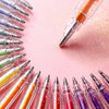 A collection of glitter gel pens arranged in a circular pattern on a pink background.