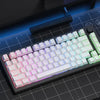 A close-up view of a mechanical keyboard, keycaps, mouse, and controller laid out on a dark surface with a blue grid backgrou