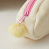 A close-up of a white Chiikawa plush pencil case with a pink zipper and yellow pom-pom detail.