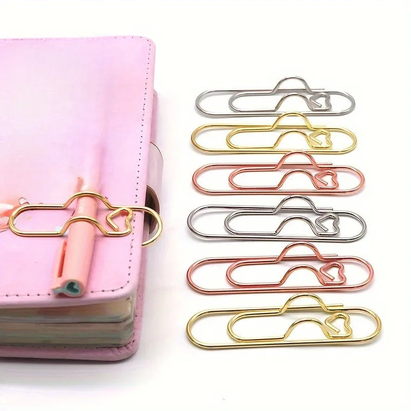 A set of gold and rose gold magnetic pen clips and page markers for organizing documents.