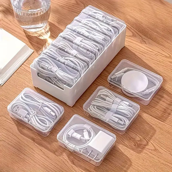 A white plastic organizer box filled with coiled white cables and connectors for desk or travel storage.