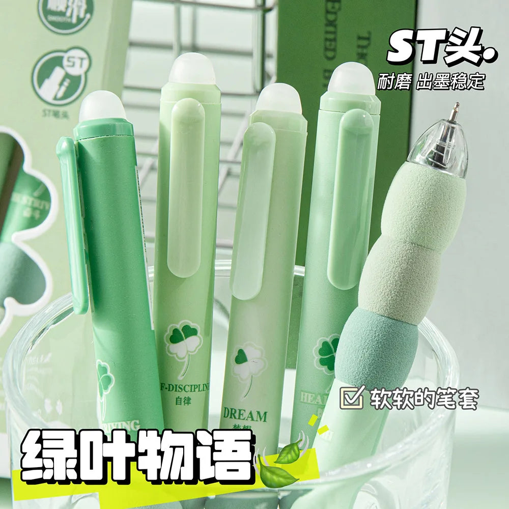 A set of light green erasable gel pens with soft grips are displayed in a clear container.