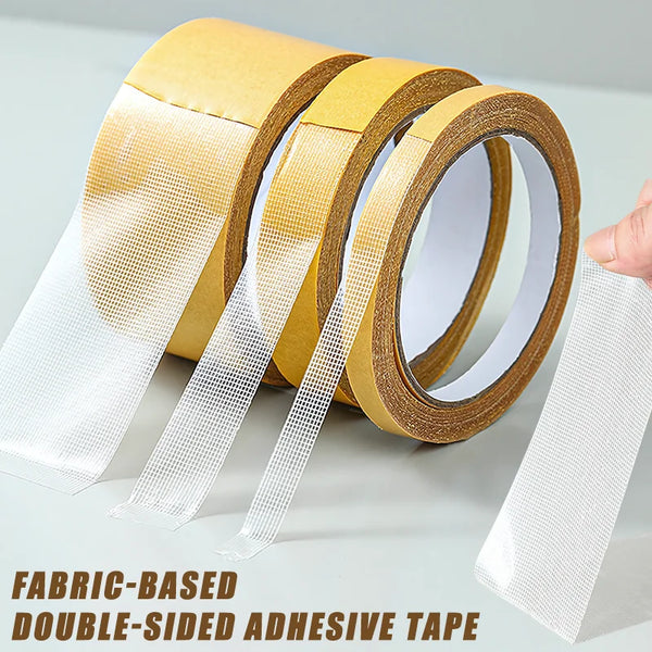 Rolls of fabric-based double-sided adhesive tape in gold and clear packaging with strips unwound