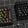 A close-up view of a black mechanical keyboard with crystal clear RGB keycaps and a separate Shift keycap.
