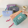 A collection of purple, blue, and orange checkered pencil cases are displayed on a white surface.