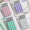 A collection of cute mini silent calculators in various colors and designs, including pink, purple, and white.