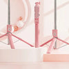 A pink 360° rotating selfie stick with a Bluetooth remote and LED light is displayed above a white vanity sink.