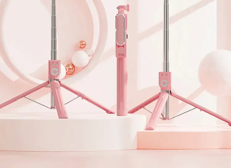 A pink 360° rotating selfie stick with a Bluetooth remote and LED light is displayed above a white vanity sink.