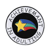 Enamel pin featuring a yellow star with blue and green stripes on a black background surrounded by text.