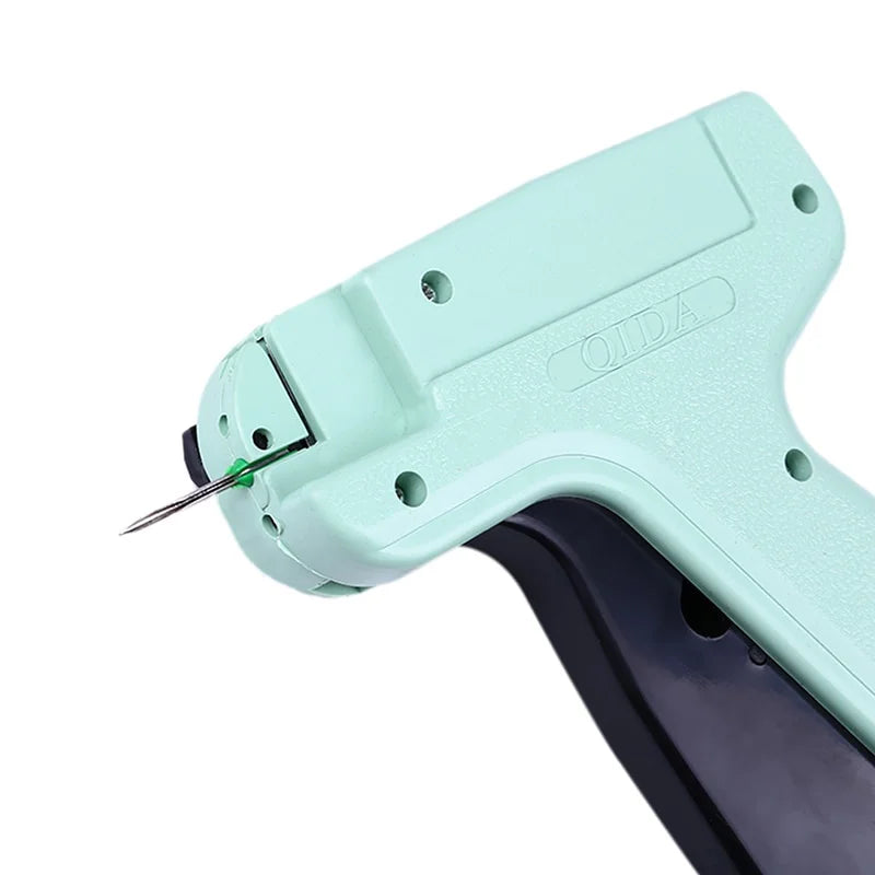A light mint green professional apparel tagging gun with a needle tip shown in a close-up view.