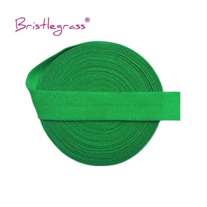 A green bristleglass elastic hair tie or trim rolled into a cylinder.