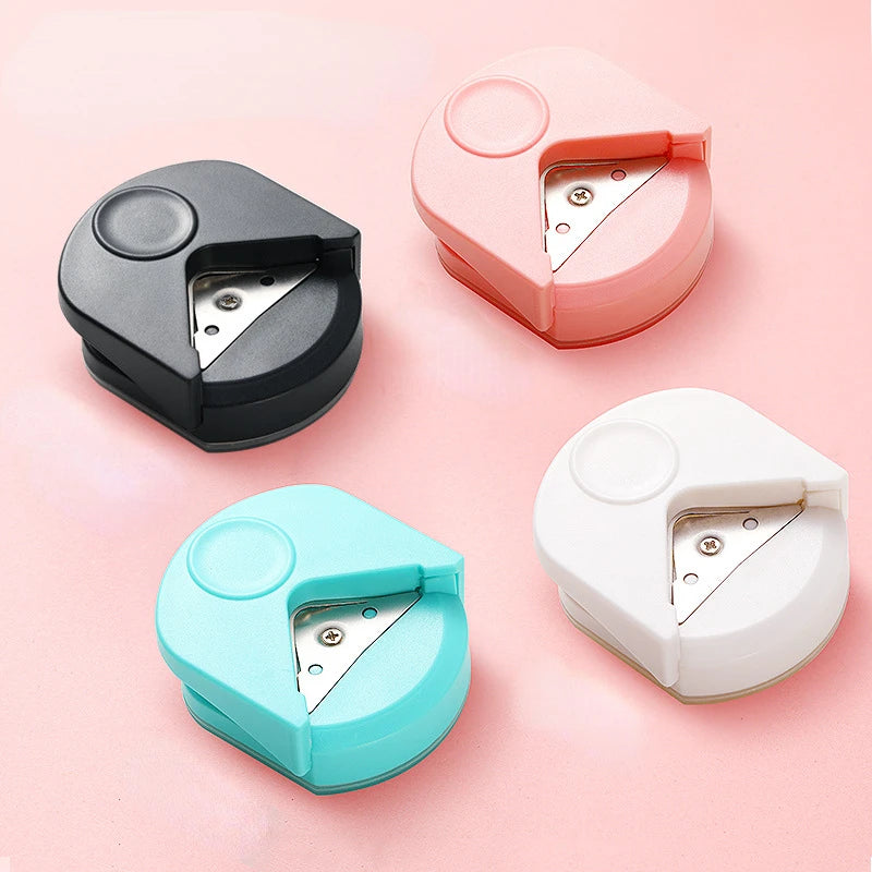 Three precision corner cutters in pink, black, and light blue are displayed on a pink background.