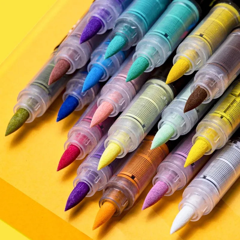 A collection of colorful acrylic paint markers with various tips arranged diagonally on a yellow surface.