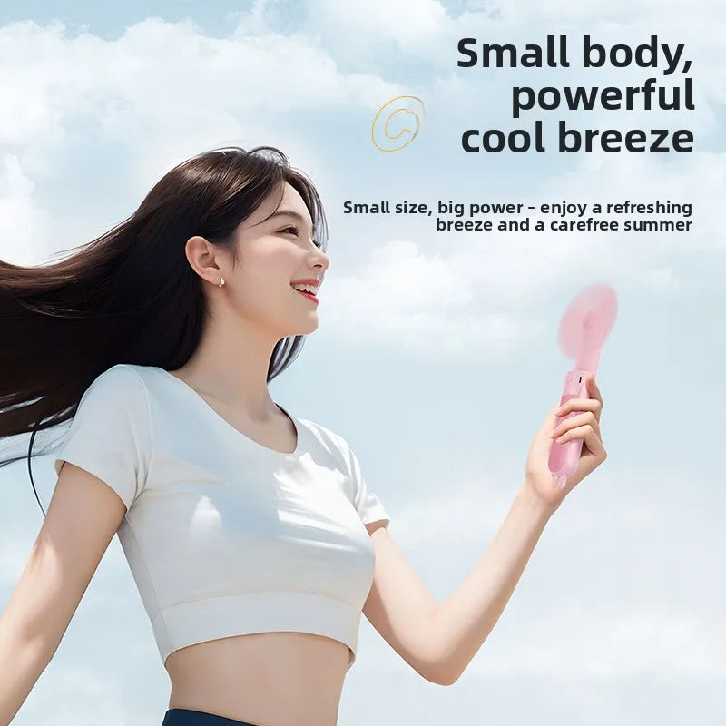 A woman is holding a pink portable foldable rabbit mini fan outdoors on a sunny day.