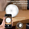 A hand holds a smartphone displaying a soft LED light source illuminating a cabinet or wardrobe interior.
