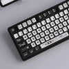 A close-up view of a black mechanical keyboard featuring transparent pudding style PBT keycaps.