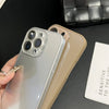 A hand holds a silver iPhone with a clear protective case next to a beige iPhone, set against a dark background.