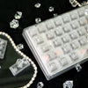 Nahaufnahme klarer und gefrosterter PC-Tastenkappen für eine mechanische Tastatur auf einer dunklen Oberfläche.