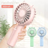 A pink handheld fan with a mesh grille is shown being held by a hand, alongside two versions of the fan.