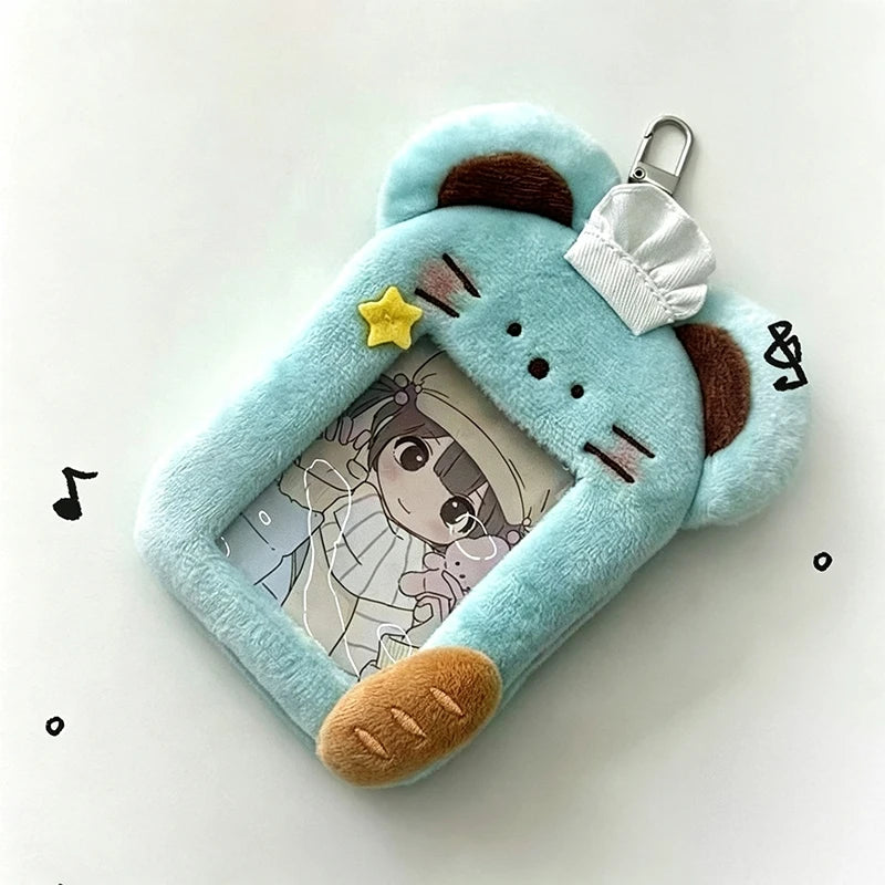 A light blue plush holder shaped like a bear, featuring a clear window displaying a K-pop photocard.
