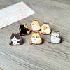 Una colección de pines de esmalte con gatos lindos en varios colores y expresiones.