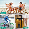 A person is using a portable combination lock box for secure storage on a beach.