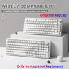 White mechanical keyboard keycaps displayed on a white box with loose keycaps.
