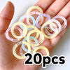 A hand holds a collection of colorful reusable plastic binding rings in various translucent shades.