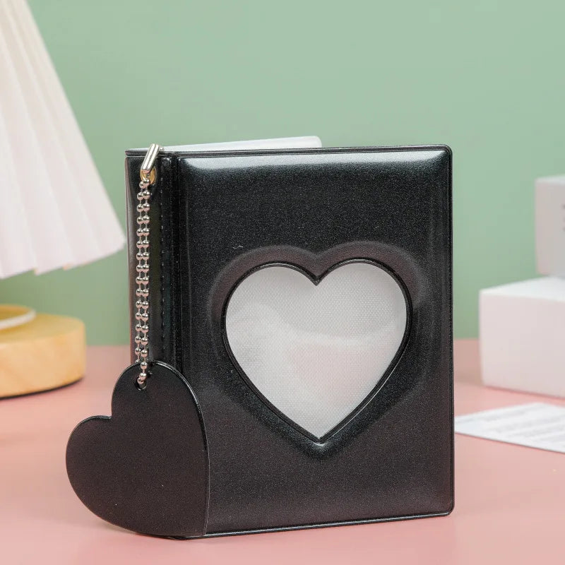 A black hollow photo card binder shaped like a heart with a silver chain detail.
