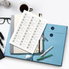 A light blue expanding accordion document organizer file folder with a white sheet of paper and a silver pen on a white desk.