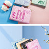 A collection of marble budget binders and cash envelopes in various shades of green, pink, and beige.