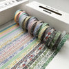 A collection of colorful retro washi tape rolls arranged on a sheet, with a white box in the background.