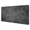 A rectangular dark gray abstract art desk mat with a non-slip rubber base.
