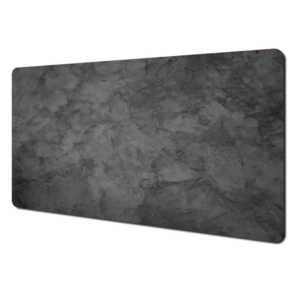A rectangular dark gray abstract art desk mat with a non-slip rubber base.