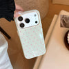 A light pink phone case with white polka dots is held by a hand, shown in a close-up shot.