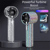 A silver and iridescent mini portable LED turbine fan with a digital display is shown on a dark background.
