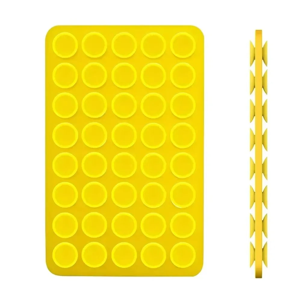 A yellow double-sided silicone phone mount grip with multiple circular holes.